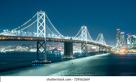 Oakland Bay Bridge And The City Light At Night.