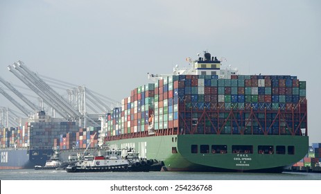 OAKLAND, CA - FEBRUARY 19, 2015: China Shipping Container Line Cargo Ship SPRING entering the Port of Oakland. Four tugboats worked in tandem to push the behemouth vessel sideways to the dock.