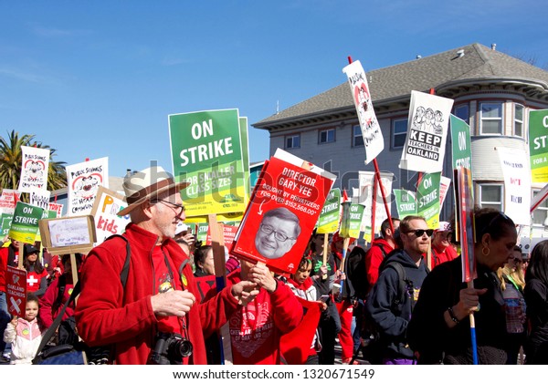 Oakland, CA - February 22, 2019: Unidentified\
participants at Oakland teachers strike day 2 rally at DeFremery\
Park, then marching downtown. Fighting for smaller class sizes and\
bigger paychecks.