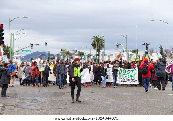 Oakland, CA - February 26, 2019: Unidentified\
participants in Oakland teachers strike day 4 marching down\
International to Roots Academy. Fighting for smaller class sizes\
and bigger paychecks.