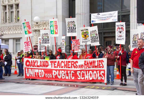 Oakland, CA - February 28, 2019: Unidentified\
participants at Oakland teachers strike day 6 rallying at Frank\
Ogawa Plaza downtown. Fighting for smaller class sizes and bigger\
paychecks.