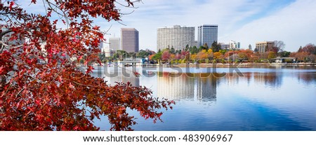 Oakland, CA Lake Merritt view framed by red maple leaf tree in autumn