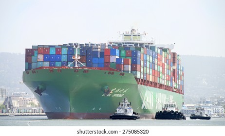 OAKLAND, CA - MAY 03, 2015: China Shipping Lines Cargo Ship CSCL SPRING entering the Port of Oakland with multiple tugboats assisting the vessel to maneuver. 