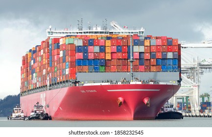Oakland, CA - Nov 18, 2020: Multiple tugboats work in tandem to assist Cargo Ship ONE CYGNUS to maneuver out of the Port of Oakland, the fifth busiest port in the United States.