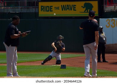 Oakland, California - August 28, 2021: New York Yankees Pitcher Jameson Taillon Throws A Bullpen As Bullpen Coach Mike Harkey Takes Notes Before A Game Against The Oakland A's At RingCentral Coliseum.