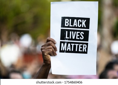 OAKLAND, CALIFORNIA, USA - 6/10/2020: Protestor Raises Black Lives Matter Sign During Protest For The Murder Of George Floyd.