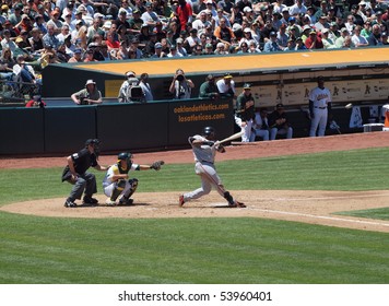 OAKLAND -  MAY 23: Bay Bridge Series: Giants Pablo Sandoval At Bat Making Contact With Kurt Suzuki Catching And Umpire Standing Behind Them. Taken May 23, 2010 Coliseum Oakland California.