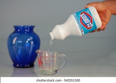 OAKLAND, USA - JUL 20, 2005: Hand Pouring Bleach On Measuring Cup