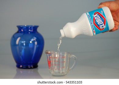 OAKLAND, USA - JUL 20, 2005: Hand Pouring Bleach On Measuring Cup