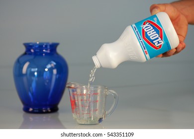 OAKLAND, USA - JUL 20, 2005: Hand Pouring Bleach On Measuring Cup