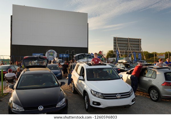 Oakville, Ontario, Canada - August 16, 2017:\
Standing boy looking out sunroof at Volkswagen drive in movie\
theatre event in Oakville Canada at\
sundown