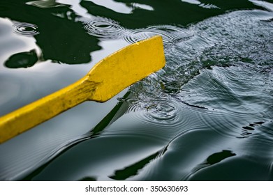 Oar Of Boat Touching Water And Causing Splash And Ripples In The Water.