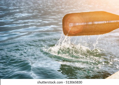 Oar of boat touching water and causing splash and ripples in the water. - Shutterstock ID 513065830