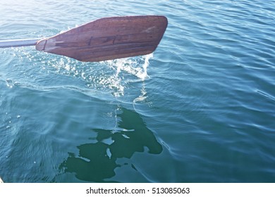 Oar Of Boat Touching Water And Causing Splash And Ripples In The Water.