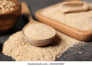 Oat bran in wooden spoon and grains on grey table, closeup - Powered by Shutterstock