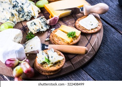 Oat crackers with cheese selection on wooden rustic board - Powered by Shutterstock