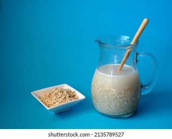 Oat Flakes, A Jug Of Oat Milk. The Process Of Making Vegetable Milk