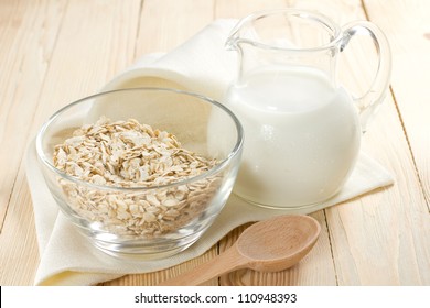 Oat Flakes On A Glass Bowl And Jug Of Milk