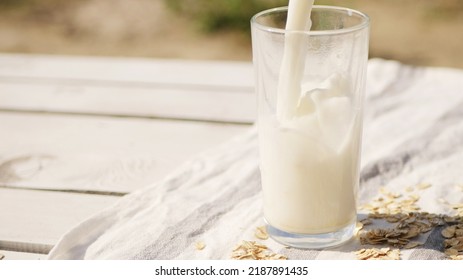 Oat Milk Pouring Into Glass. Dairy And Lactose Free Drinks. Vegan Diet 