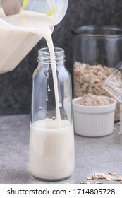 Oat Milk. Pouring The Strained Oat Milk Into A Glass Jar. Process Of Making Oat Milk. 