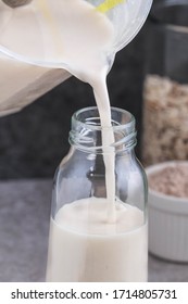 Oat Milk. Pouring The Strained Oat Milk Into A Glass Jar. Process Of Making Oat Milk. 