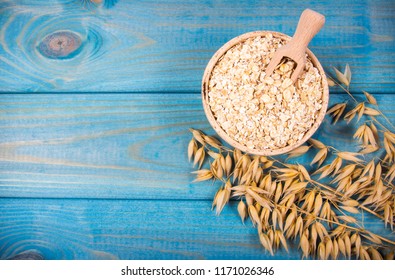 Oat and oatmeal on the wooden background. Healthy eating concept.