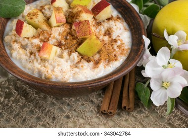 Oatmeal With Apple And Cinnamon In The Bowl And Cinnamon Sticks  