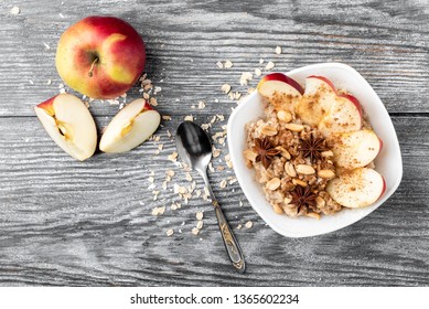 Oatmeal With Apple And Cinnamon On Gray Wooden Background.