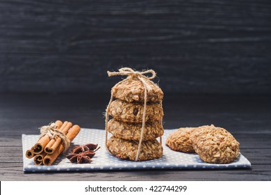 Oatmeal and banana cookies with raisins, tied with a twine, cinnamon sticks and star anise on napkin on black wooden table. Food, holiday, cooking, baking background. Concept of home, healthy eating. - Powered by Shutterstock