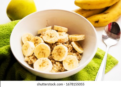 oatmeal with banana slices in a white plate on a white background