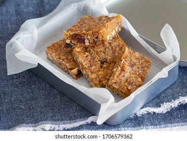 Oatmeal bars flapjacks close up macro shot with nuts and fruit and seeds on white background