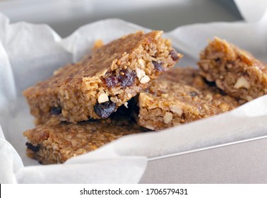 Oatmeal bars flapjacks close up macro shot with nuts and fruit and seeds on white background