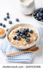 Oatmeal Bowl With Blueberries And Flax Seeds On Blue Textile. Healthy Breakfast Meal