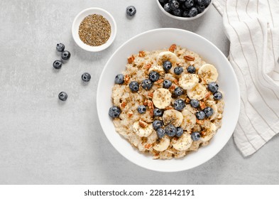 Oatmeal Bowl, Oat Porridge with Blueberry, Banana and Pecans in a Bowl on Bright Grey Background, Healthy Snack or Breakfast - Powered by Shutterstock