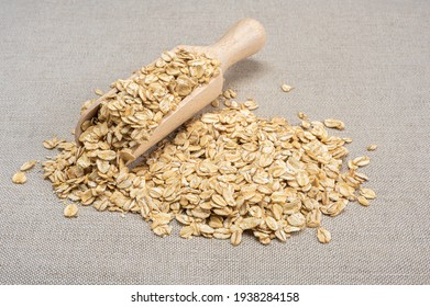 oatmeal cereal. scoop and pile of oatmeal with its plant. Dry rolled oatmeal. wooden scoop spoon with Oat flakes.
