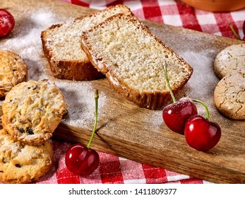 Oatmeal cookies and cherry on kitchen cutting board gingham checkered cotton fabric on table in village style for picnic. New dishes in expensive cafe. Culinary masterpiece on table. - Shutterstock ID 1411809377