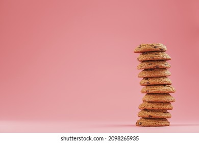 Oatmeal Cookies With Chocolate Are Stacked On A Pink Background.