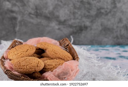 Oatmeal Cookies In A Wooden Basket On A Pink Kitchen Towel