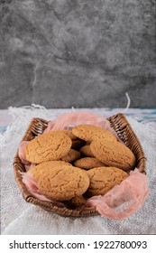 Oatmeal Cookies In A Wooden Basket On A Pink Kitchen Towel