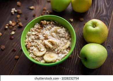 oatmeal with fruit and dried fruits.bananas,apples.wooden table.healthy organic food concept. - Powered by Shutterstock