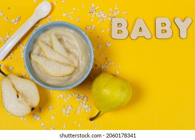 Oatmeal Porridge For The Baby From Ground Cereals In A Blue Bowl, Ripe Juicy Pears, A Spoon On A Bright Yellow Background. Space For Text. Baby's First Complementary Food, Baby Nutrition.