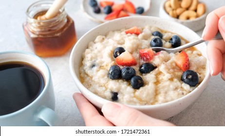 Oatmeal porridge with berries and honey. Healthy breakfast food. Eating healthy breakfast porridge oats