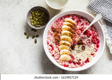 Oatmeal Porridge With Berries, Peanut Butter, Banana And Chia In A White Bowl.