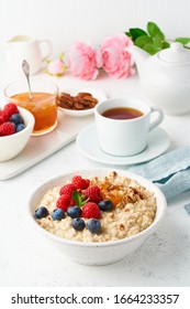 Oatmeal Porridge With Blueberry, Raspberries, Jam And Nuts In White Bowl, Dash Diet With Berries, White Background, Side View, Vertical. Healthy Diet Breakfast