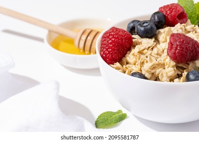 Oatmeal Porridge With Blueberry, Raspberries In White Bowl, Dash Diet With Berries, White Background. Healthy Diet Breakfast.