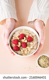 Oatmeal Porridge Bowl With Berries And Nuts In Woman's Hands. Concept Of Healthy Vegan Diet, Clean Eating, Weight Loss. Top View