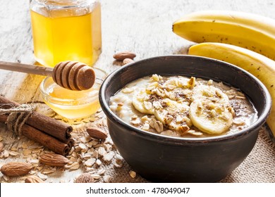 oatmeal porridge in dark ceramic bowl. with honey, banana, cinnamon and nuts. healthy breakfast. close up - Powered by Shutterstock