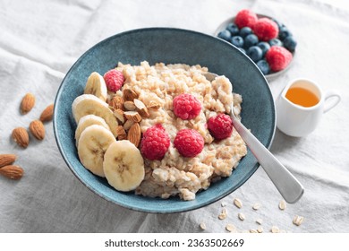 Oatmeal porridge raspberry banana and nuts in bowl