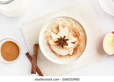 Oatmeal Porridge With Red Apple Slices And Cinnamon. Healthy Diet Breakfast Concept. Top View, Flat Lay