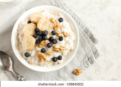 Oatmeal porridge with walnuts, blueberries and banana in bowl  - healthy rustic breakfast - Shutterstock ID 538845832